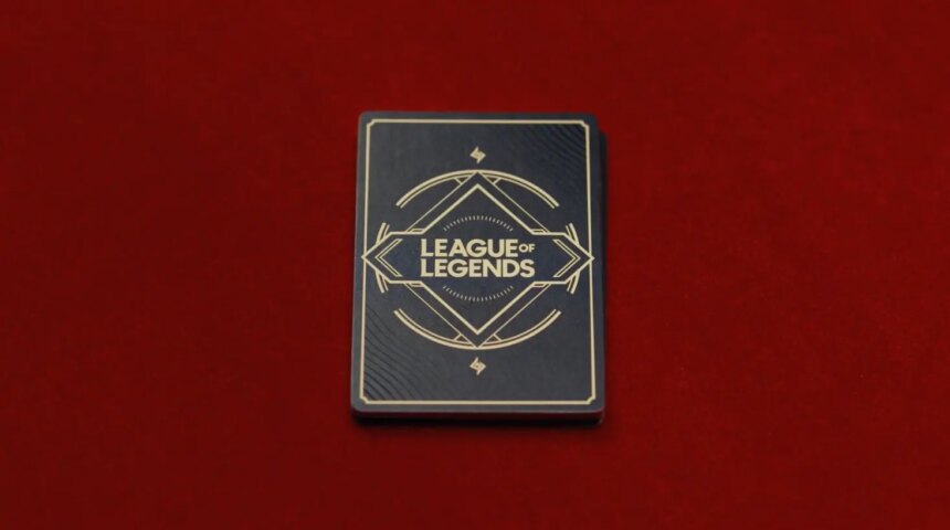 A deck of cards with the League of Legends wordmark on them against a red background